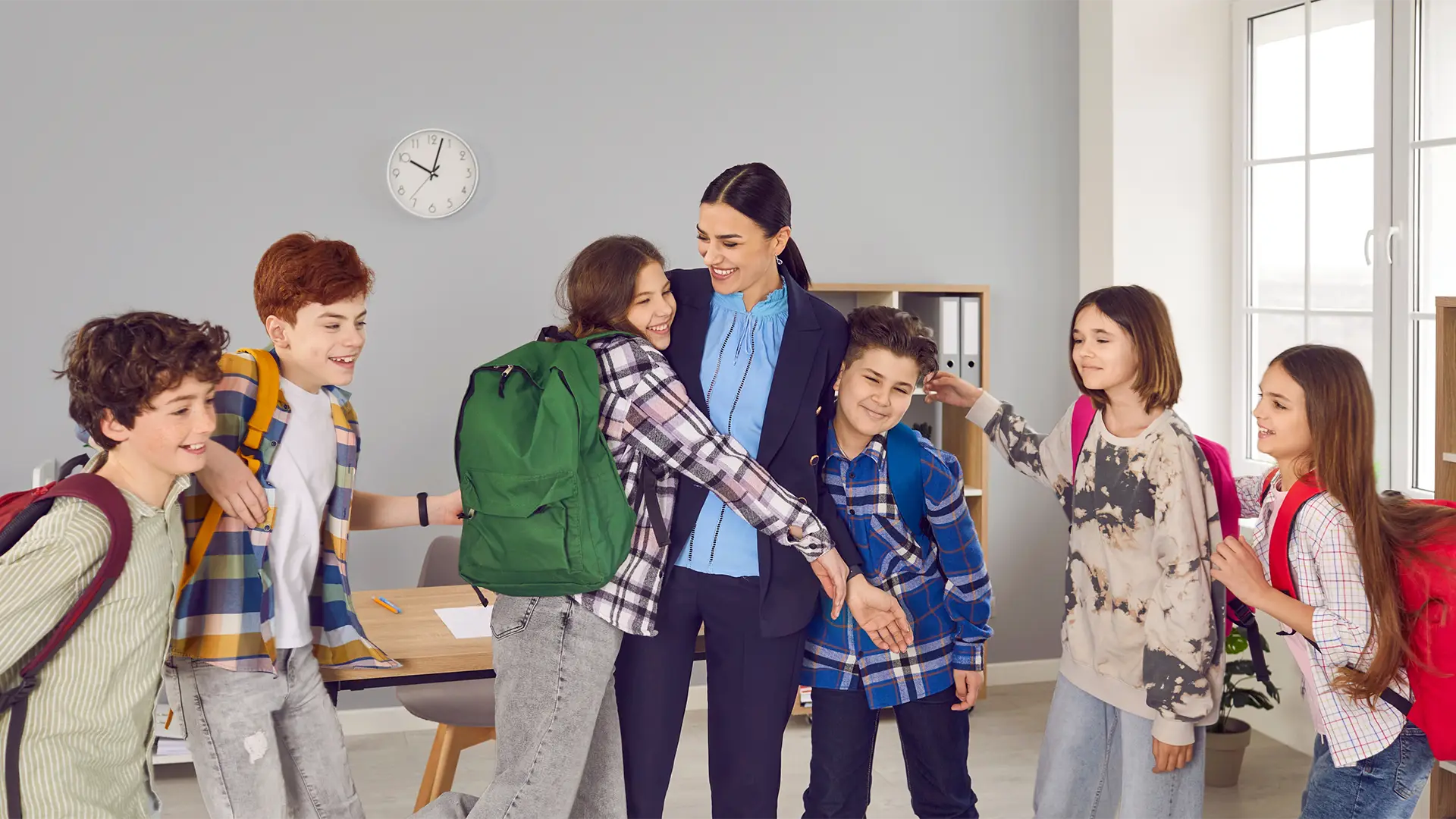 Image of children going for a group hug with teacher